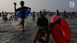 Pengunjung bermain dan berenang di kawasan Beach Pool, Taman Impian Jaya Ancol, Jakarta, Kamis (6/6/2019). Hari kedua Lebaran banyak dimanfaatkan warga untuk berlibur dan berekreasi bersama keluarga atau kerabat dengan mengunjungi pantai Ancol. (Liputan6.com/Johan Tallo)