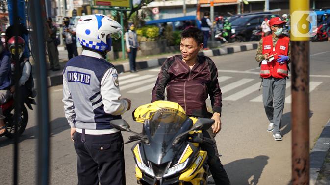 Petugas Dishub melakukan sosialisasi penggunaan masker kepada pengendara motor di kawasan Depok, Jawa Barat, Senin (20/7/2020). Pemkot Depok melalui Gugus Tugas Percepatan Penanganan COVID-19 turun ke jalan tiga hari ke depan untuk menggencarkan Gerakan Bermasker. (Liputan6.com/Immanuel Antonius)