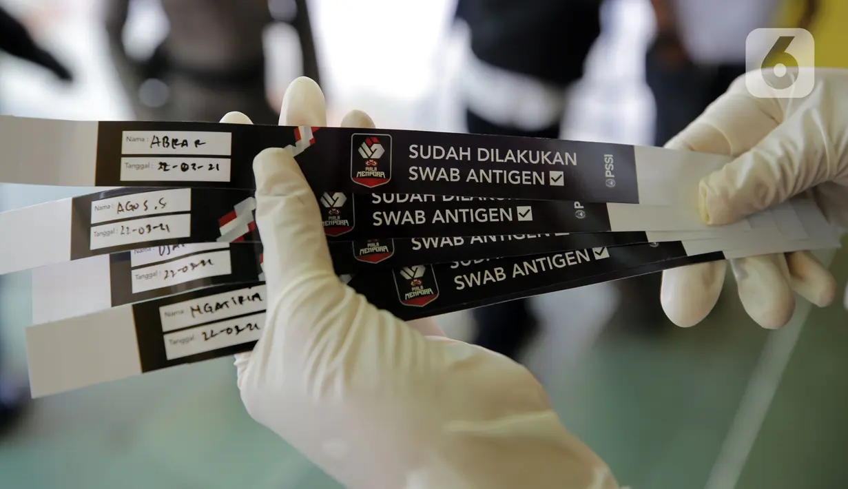 Petugas medis menunjukkan gelang tanda sudah melakukan swab antigen bagi yang bertugas di Stadion Kanjuruhan jelang pertandingan sepak bola Piala Menpora 2021, Malang, Jawa Timur, Senin (22/3/2021). (Bola.com/Arief Bagus)