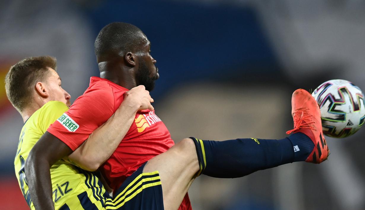 Pemain Fenerbahce, Serdar Aziz (kiri) menghadang pemain Kaysersispor, Julien Kanga dalam lanjutan Turkish Super League di Istanbul, Senin (25/1/2021). (Foto: AFP/Ozan Kose)