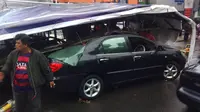 Sebuah sedan tertimpa baliho roboh akibat hujan es dan angin kencang yang menerjang Kota Bandung, Jabar. (Liputan6.com/Kukuh Saokani)