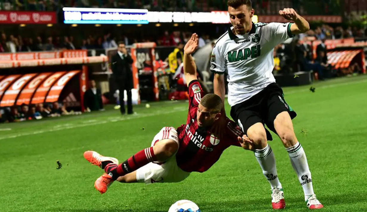 Pemain belakang Sassuolo, Alessandro Longhi (kanan) berusaha menahan laju pemain depan AC Milan, Adel Taarabt, saat berlaga di Stadion San Siro, (18/5/2014). (AFP PHOTO/Giuseppe Cacace)