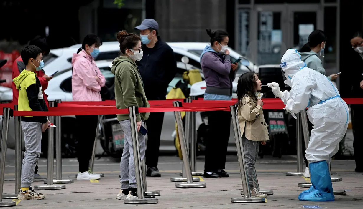 <p>Seorang petugas kesehatan (kanan) mengambil sampel swab dari seorang anak untuk diuji virus corona COVID-19 di tempat pengumpulan swab di Beijing, China, Selasa (10/5/2022). Jutaan orang di Beijing tinggal di rumah pada 9 Mei ketika Ibu Kota China tersebut mencoba untuk menangkis wabah COVID-19 dengan pembatasan pergerakan. (Noel Celis/AFP)</p>
