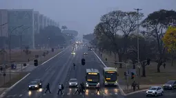 Brasilia, ibu kota Brasil yang modern, terbangun dalam dua hari terakhir dan mendapati gedung-gedung ikoniknya diselimuti oleh asap. (AP Photo/Eraldo Peres)