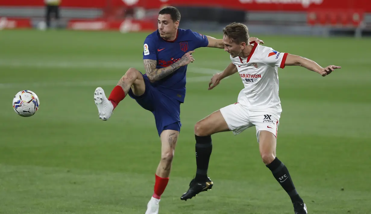 Pemain Atletico Madrid, Jose Gimenez, berebut bola dengan pemain Sevilla, Luuk de Jong, pada laga Liga Spanyol di Stadion Ramon Sanchez-Pizjuan, Minggu (4/4/2021). Sevilla menang dengan skor 1-0. (AP Photo/Angel Fernandez)