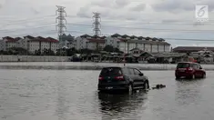 Dua mobil berada di genangan air akibat banjir rob di kawasan Muara Angke, Jakarta, Kamis (4/1). Banjir rob yang merendam kawasan Muara Angke itu disebabkan oleh fenomena Supermoon. (Liputan6.com/JohanTallo)