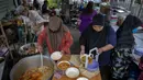 Sukarelawan memindahkan makanan ke dalam kotak di Masjid Bang Aw, Bangkok, Thailand, Kamis (30/4/2020). Setiap hari selama Ramadan, sukarelawan membagikan makanan kepada 150 keluarga sekitar Masjid Bang Aw yang tidak bisa beribadah bersama karena pandemi COVID-19. (AP Photo/Gemunu Amarasinghe)