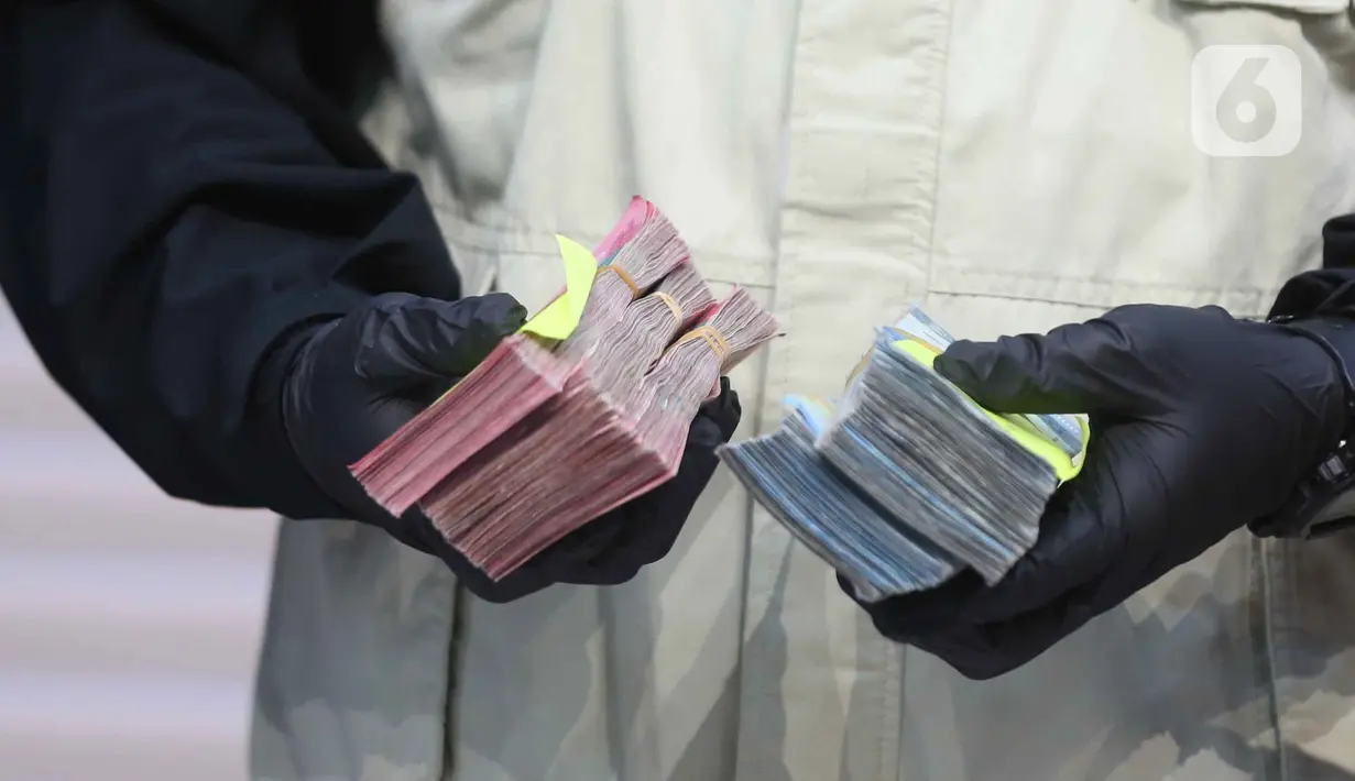 Uang tersebut merupakan bagian dari total Rp 2,7 miliar yang diduga telah diterima Gatut Sunu Wibowo dari permintaan awal sebesar Rp 5 miliar. Tampak dalam foto, tumpukan uang barang bukti terkait Operasi Tangkap Tangan (OTT) Bupati Tulungagung, Gatut Sunu Wibowo, diperlihatkan petugas di Gedung Merah Putih Komisi Pemberantasan Korupsi (KPK), Jakarta, Sabtu (11/4/2026). (Liputan6.com/Helmi Fithriansyah)