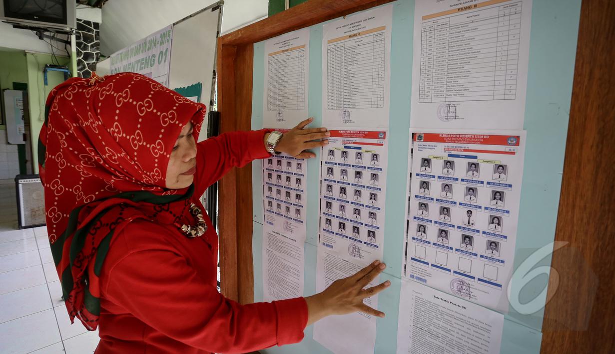 Seorang guru mempersiapkan nomor peserta siswa untuk Ujian Nasional (UN) di SDN 01 Menteng, Jakarta, Minggu (17/5/2015). Pelaksanaan UN SD akan dilakukan pada 18-20 Mei mendatang. (Liputan6.com/Faizal Fanani)