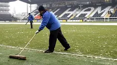 Ground staff try to clear ice from the pitch before Fulham's Premier League match against Blackburn at Craven Cottage, London, on January 10, 2009. AFP PHOTO / Glyn Kirk
