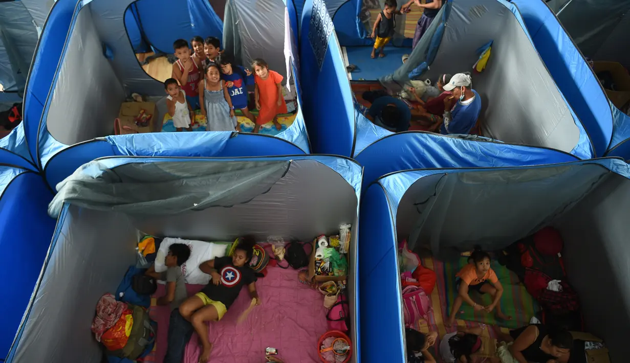 Anak-anak terdampak letusan gunung berapi berkumpul di sebuah pusat evakuasi di Tagaytay City, provinsi Cavite Filipina (17/1/2020). Ancaman gunung berapi Taal Filipina yang melepaskan potensi letusan bencana tetap tinggi. (AFP/Ted Aljibe)
