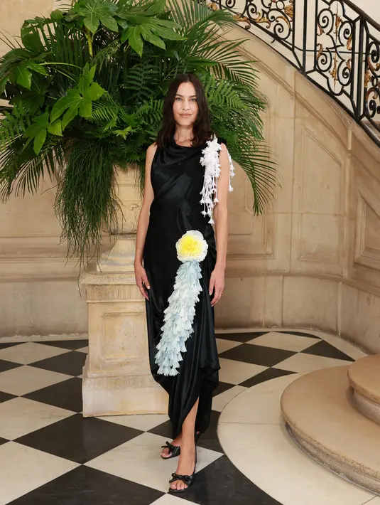 Alexa Chung terlihat effortless dengan sleevess dress hitam beraksen fringe beda warna yang estetik [Dior]