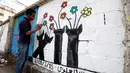 Seorang seniman melukis grafiti pada dinding di Ibu Kota Sanaa, Yaman, Kamis (15/3). Kampanye ini untuk mendukung perdamaian di negara yang terkena dampak perang. (Mohammed HUWAIS/AFP)