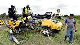 Petugas memeriksa sisa puing bus sekolah usai mengalami kecelakaan di Yaguachi-Milagro, Ekuador, Jumat (14/1). Dilaporkan sedikitnya 20 orang tewas dan 17 lainnya mengalami luka-luka. (AFP PHOTO/MAURICIO DE LA CADENA)