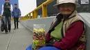 Alejandra Baldani (78) memegang permen jualannya sambil menunggu pembeli di jembatan penyeberangan di distrik San Borja, Lima, 22 Oktober 2015. Baldani mendapatkan sekitar USD 3 per hari dari hasil berjualan permen. (REUTERS / Mariana Bazo)
