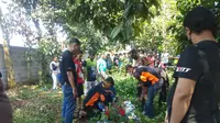 Petugas Unit Identifikasi Polres Metro Bekasi Kota mengevakuasi jasad pemuda yang diduga bunuh diri di sebuah pohon, Sabtu (14/1/2023). (Dok. Liputan6.com/Bam Sinulingga)