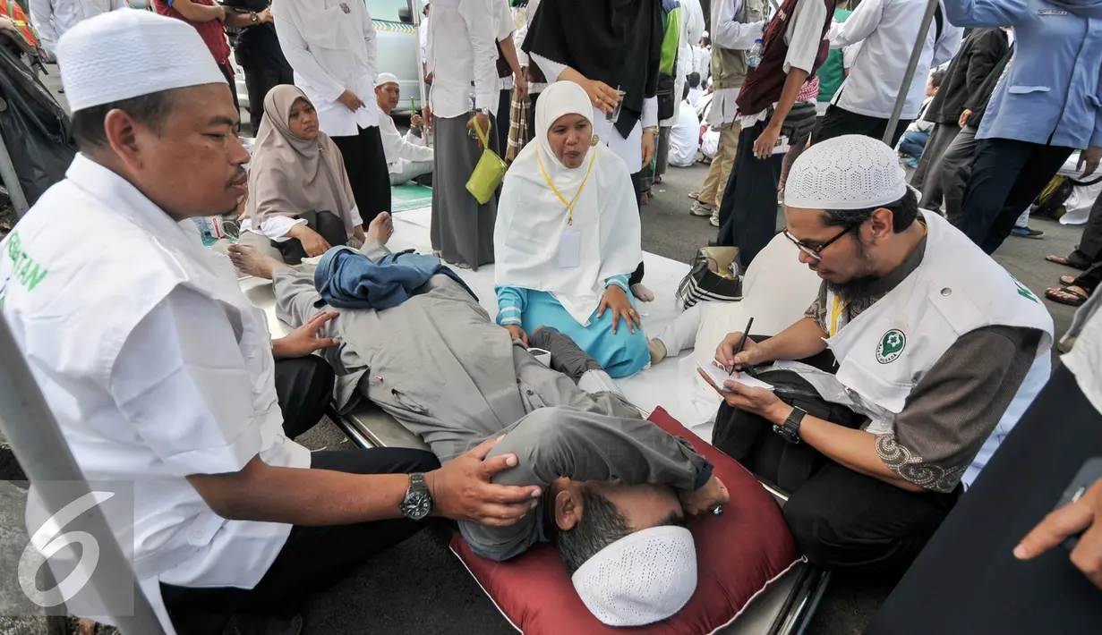 Sejumlah tim membantu demonstran yang kelelahan saat melakukan demo di depan Balai Kota, Jakarta, Jumat (4/11). Terlihat beberapa massa sedang beristirahat, dan ada juga yang sedang mendapat perawatan. (Liputan6.com/Yoppy Renato)