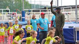 Usain Bolt membuka menembakan pistol tanda start pada lomba lari untuk anak-anak di Prague. Bolt datang ke Republik Ceska guna mengikuti pertemuan Golden Spike di Ostrava pada Jumat 20 mei 2016, (18/5/2016). (AFP/Michal Cizek)