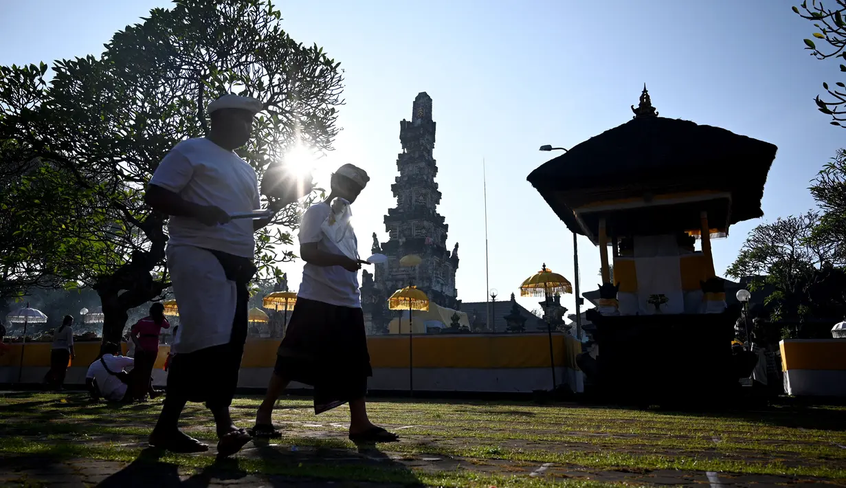Umat ​​Hindu berjalan menuju Pura Jagat Natha untuk merayakan hari raya Galungan di Denpasar, Bali, Rabu (8/6/2022).  Hari Raya Galungan dan Kuningan merupakan hari besar suci umat Hindu yang jatuh setiap enam bulan sekali. (SONNY TUMBELAKA / AFP)
