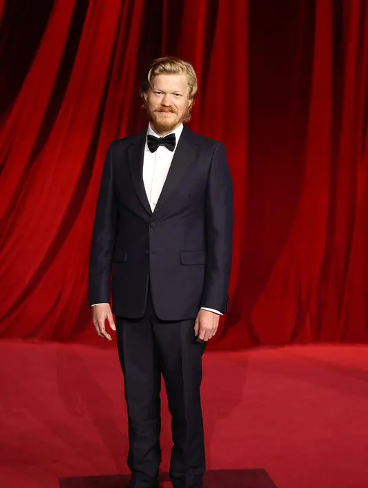 Jesse Plemons mengenakan tuksedo bertekstur biru tua, kemeja tuksedo poplin putih, dasi kupu-kupu satin hitam. Sepatu kulit hitam. Semua oleh Prada.[Prada]