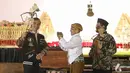 Presiden Joko Widodo (Jokowi) memainkan wayang kulit disaksikan dalang Ki Mantep Sudarsono (tengah) dalam Pagelaran Wayang Kulit 74 Tahun Indonesia Merdeka di halaman depan Istana Merdeka, Jakarta, Jumat (2/8/2019). Pagelaran wayang mengangkat tema "Kresno Jumeneng Ratu”.(Liputan6.com/Angga Yuniar)