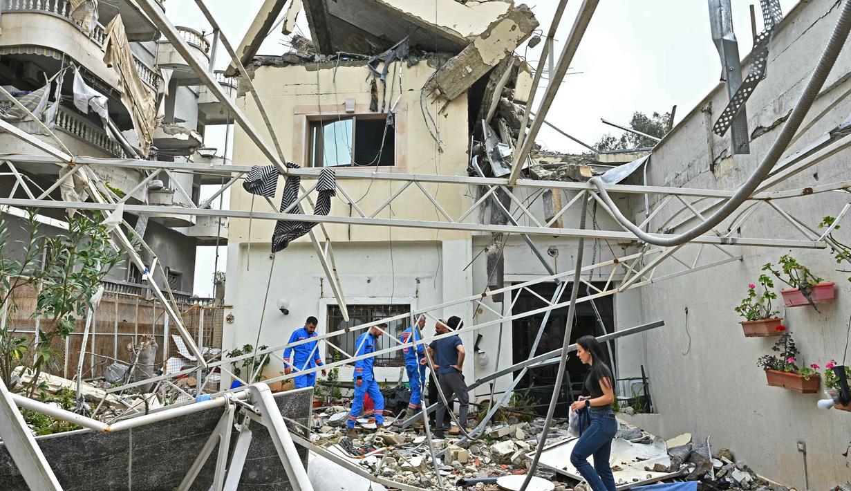 Warga memeriksa puing-puing bangunan yang hancur setelah kembali ke kota Nabatieh, Lebanon Selatan pada Sabtu 18 April 2026. Warga Lebanon, khususnya di wilayah selatan, mulai berbenah. (FADEL itani/AFP)
