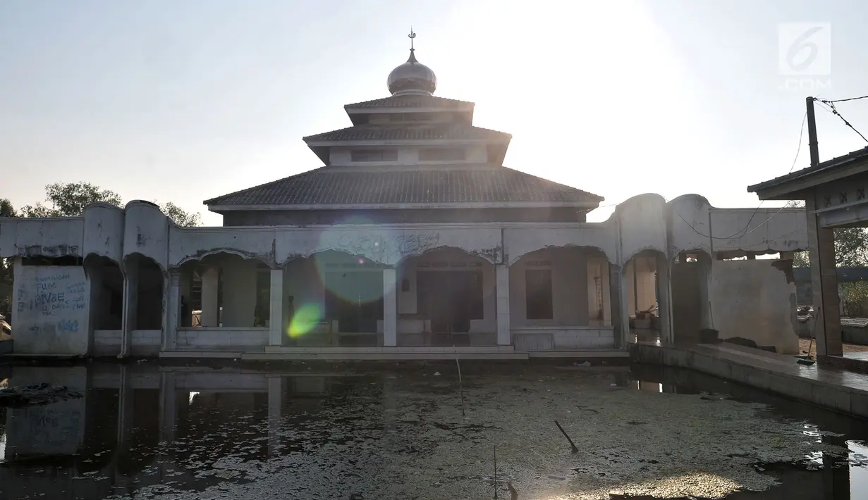 Anak-anak berada di dalam masjid dengan kondisi halaman yang penuh endapan lumpur di Kampung Beting, Desa Pantai Bahagia, Muara Gembong, Kabupaten Bekasi, Jawa Barat pada 28 Juli 2019. (merdeka.com/Iqbal S Nugroho)