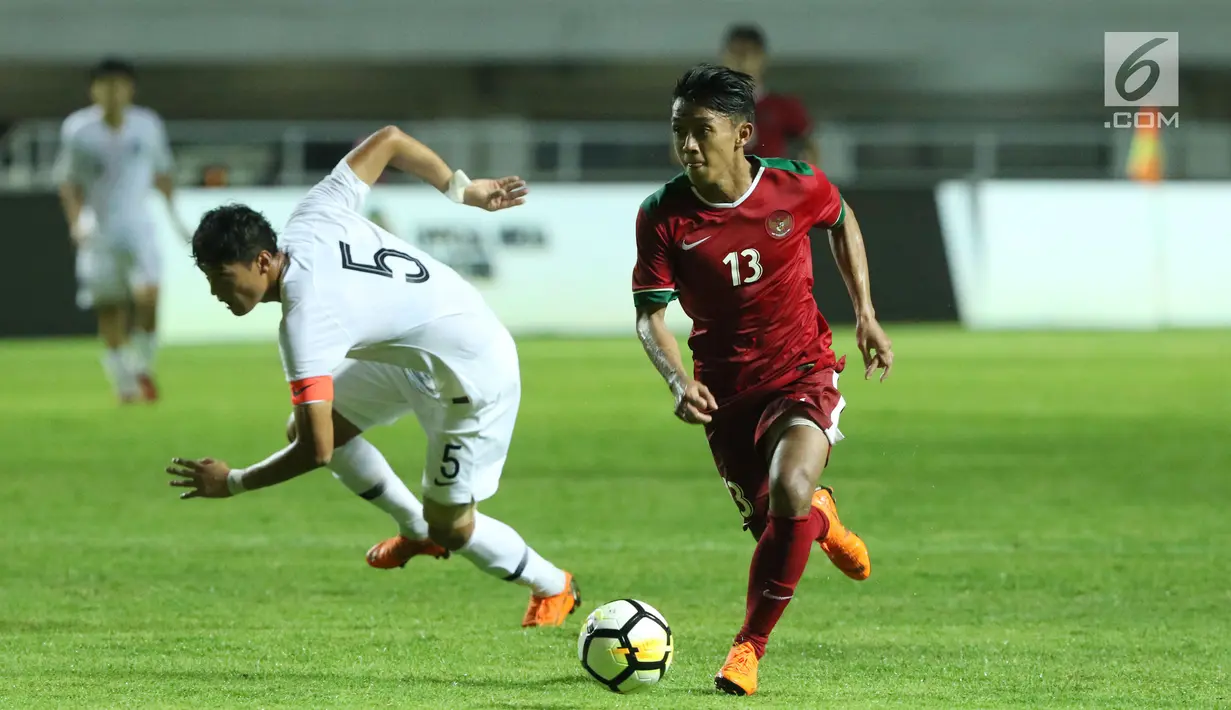 Pemain sayap Indonesia U-23, Febri Hariyadi (kanan) melewati adangan pemain Korea Selatan U-23, Kim Jeung Ho pada laga persahabatan di Stadion Pakansari, Kab Bogor, Sabtu (23/6). Indonesia U-23 kalah 1-2. (Liputan6.com/Helmi Fithriansyah)