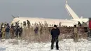 Polisi berjaga saat petugas penyelamat mengevakuasi korban jatuhnya pesawat maskapai Bek Air di dekat Bandara Almaty, Kazakhstan, Jumat (27/12/2019). Pesawat yang mengangkut 100 penumpang termasuk lima awak  itu jatuh sesaat setelah lepas landas. (AP Photo/Vladimir Tretyakov)