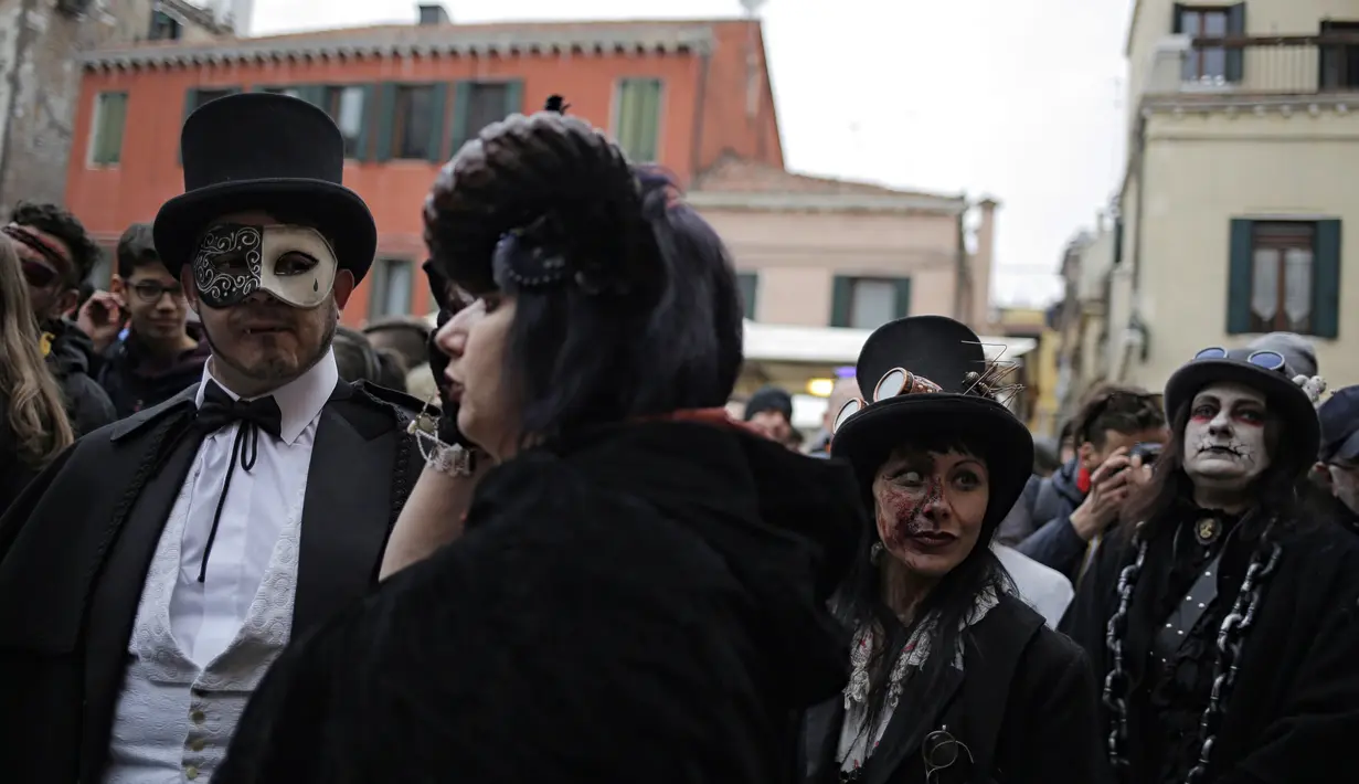Seorang wanita mengenakan kostum dan atribut seperti zombie ikut memeriahkan pembukaan Carnival of Venice 2017, Italia (11/2). Karnaval ini akan berlangsung hingga 28 Februari di pusat kota Venesia, Italia. (AFP/Marco Bertorello)