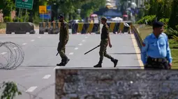 Sebagian wilayah kota Islamabad ditutup dan dijaga ketat. Tampak dalam foto, petugas polisi mengambil posisi di jalan yang dibarikade untuk memastikan keamanan menjelang kemungkinan negosiasi antara Amerika Serikat dan Iran di ibu kota Pakistan, Islamabad, Jumat 10 April 2026. (AP Photo/Anjum Naveed)