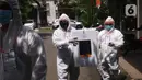 Petugas KPPS dengan mengenakan APD lengkap menuju rumah warga yang sakit untuk memberikan hak pilihnya dalam Pilkada Kota Tangerang Selatan di Paku Jaya, Serpong Utara, Rabu (9/12/2020). Mereka mendatangi warga yang tidak bisa mencoblos di TPS karena sakit. (Liputan6.com/Angga Yuniar)