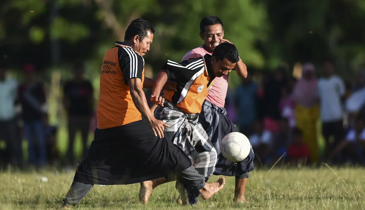 Penduduk desa bermain sepak bola dengan mengenakan sarung saat merayakan HUT ke-74 RI di Blang Pidie provinsi Aceh (17/8/2019). Indonesia merayakan kemerdekaan yang ke-74 dari pemerintahan kolonial Belanda. (AFP Photo/Chaideer Mahyuddin)