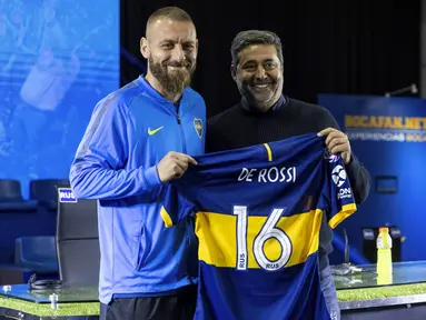 Mantan gelandang AS Roma, Daniele De Rossi memegang jersey klub barunya foto bersama Presiden Boca Juniors Daniel Angelici selama pengenalan dirinya di Buenos Aires, Argentina (29/7/2019). De Rossi menandatangani kontrak satu tahun dengan Boca Juniors. (AP Photo/Tomas F. Cuesta)