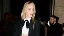 Di sisi lain, Jean Campbell membawa sentuhan tailoring klasik dengan twist modern. Ia mengenakan cropped blazer yang dipadukan dengan kemeja putih dan dasi hitam, menciptakan siluet androgini yang tajam namun tetap sensual.