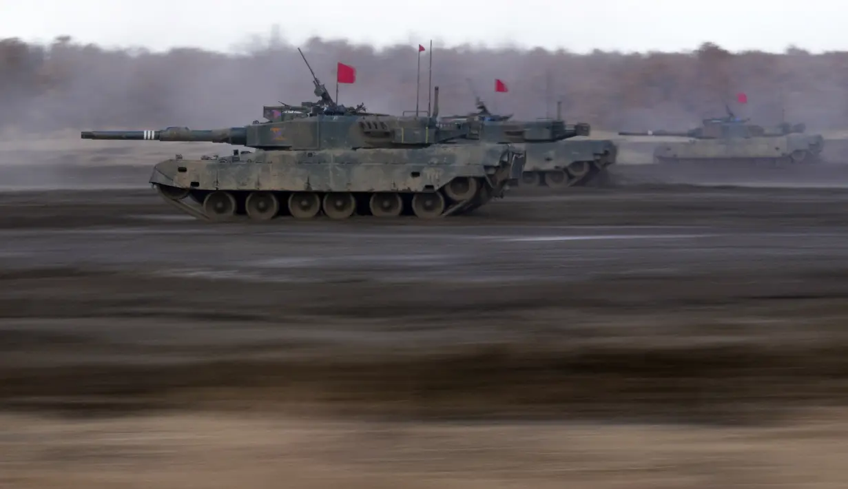 Tank Angkatan Darat Bela Diri Jepang Type 90 melaju menuju sasaran saat latihan tahunan dengan peluru tajam di Minami Eniwa Camp, Eniwa, Pulau Hokkaido, Jepang, 6 Desember 2021. Jepang terus membangun kekuatan militer. (AP Photo/Eugene Hoshiko)