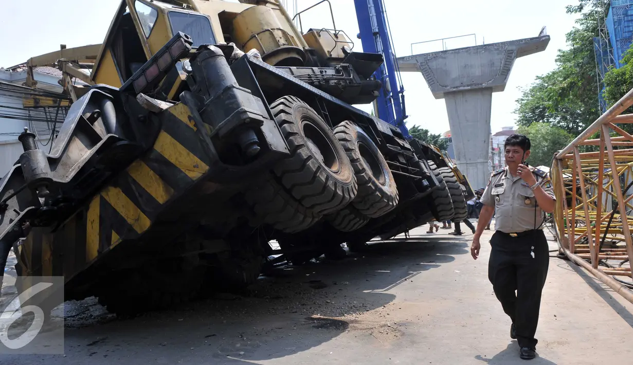 Petugas kepolisian mengevakuasi crane yang jatuh di Jalan Kyai Maja, Jakarta Selatan, Kamis (15/10/2015). Alat besar yang tengah melakukan proyek ‎jalan layang ini menimpa salah satu rumah warga yang berada di sisi kanan jalan. (Liputan6.com/Helmi Afandi)