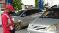 Petugas SPBU saat mencatat nopol kendaraan yang hendak mengisi BBM subsidi. (Liputan6.com)