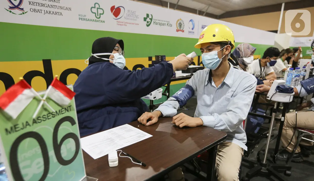 Petugas medis mengukur suhu tubuh peserta vaksin Sentra Vaksinasi Sinergi Sehat di Jakarta, Selasa (24/08/2021). Sentra Vaksinasi yang digelar ILUNI UI menyediakan 2.000 dosis vaksin per hari menggandeng 10 Rumah Sakit Vertikal Indonesia (ARVI) di Jakarta. (Liputan6.com/Fery Pradolo)