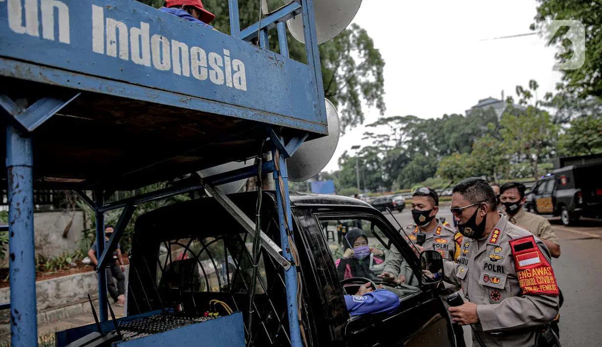 Petugas kepolisian yang berjaga memberhentikan mobil komando aksi di sekitar Gedung DPR, Jakarta, Jumat (14/8/2020). Polda Metro Jaya melarang adanya unjuk rasa di depan Gedung DPR/MPR yang bertepatan dengan sidang tahunan sekaligus pidato kenegaraan Presiden Jokowi. (Liputan6.com/Faizal Fanani)