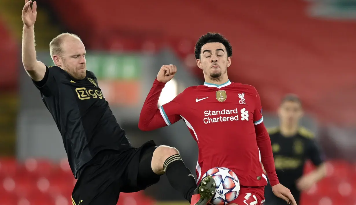 Gelandang Ajax Amsterdam, Davy Klaassen berebut bola dengan gelandang Liverpool, Curtis Jones pada matchday kelima Grup D Liga Champions di Anfield, Selasa (1/12/2020). Curtis Jones mencetak gol satu-satunya yang membawa Liverpool melaju ke babak 16 besar. (Michael Regan/Pool via AP)