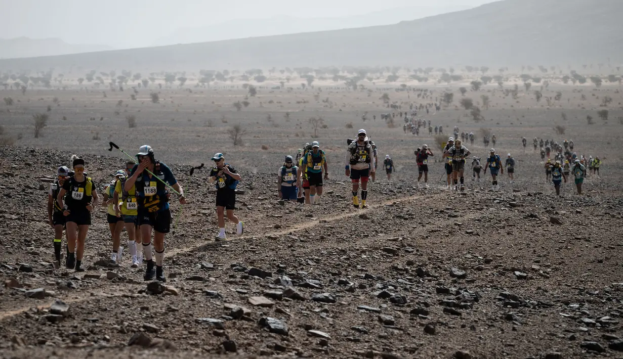 Sejumlah pelari berkompetisi pada stage kedua Marathon des Sables 2023 yang menempuh antara Oued Tijekht hingga Jebel El Otfal di Gurun Sahara, Maroko, 24 April 2023. Ajang yang berlangsung dari 21 April hingga 1 Mei 2023 tersebut diikuti oleh 1200 pelari dan akan menempuh 250 km. (AFP/Jean-Philippe Ksiazek)