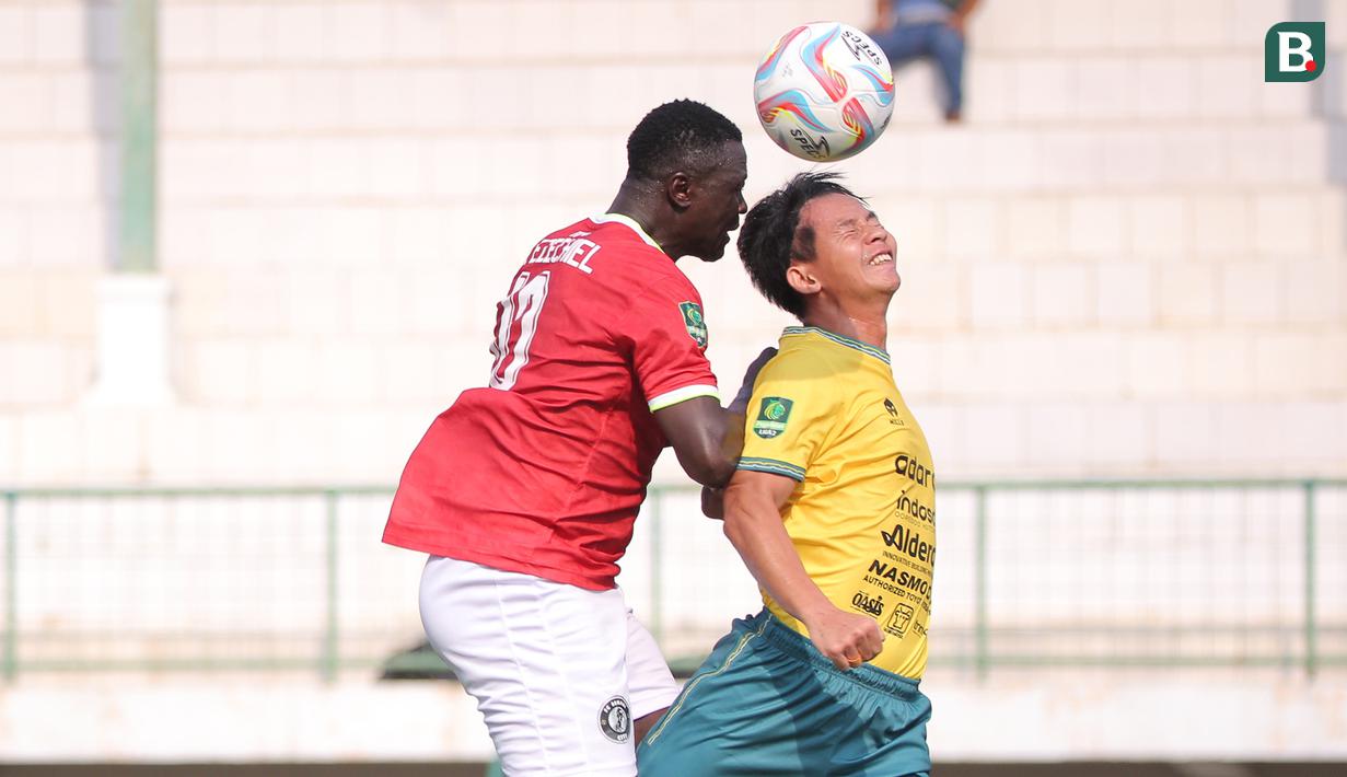 <p>Pemain FC Bekasi City, Ezechiel Ndouasel (kiri) berduel udara dengan pemain Nusantara United FC, Risna Prahalabenta pada laga lanjutan Grup B Pegadaian Liga 2 2023/2024 di Stadion Singaperbangsa, Kabupaten Karawang, Jawa Barat, Minggu (12/11/2023). (Bola.com/Ikhwan Yanuar)</p>