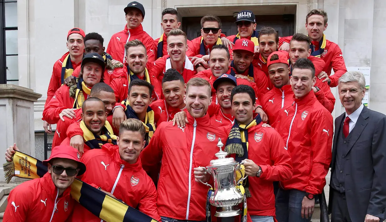 Pemain Arsenal dan manajer Arsene Wenger berpose bersama sebelum melakukan parade keliling kota usai meraih Piala FA di London, Inggris, (31/5/2015). Arsenal meeraih Trofi piala FA usai mengalahkan Aston Villa 4-0. (REUTERS/Neil Balai)