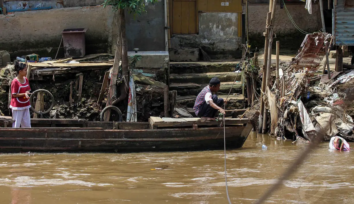 Jauhnya jarak jembatan penyebrangan membuat sejumlah warga lebih memilih menggunakan jasa perahu eretan di sungai Ciliwung, Kamis (24/4/14). (Liputan6.com/Faizal Fanani)