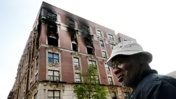 Penghuni apartemen yang terbakar memeriksa lokasi kejadian di kawasan Harlem, New York, AS, Rabu (8/5/2019). Keenam korban tewas yang masih satu keluarga diketahui bernama Andrea Pollidore (45), Mac Abdularaulph (33), Nakiyra (11), Andre (8), Brooklyn (6), dan Ellijah (4). (AP Photo/Richard Drew)