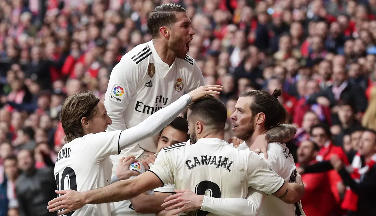 Para pemain Real Madrid merayakan gol yang dicetak oleh Gareth Bale ke gawang Atletico Madrid pada laga La Liga di Stadion Wanda Metropolitano, Sabtu (9/2). Real Madrid menang 3-1 atas Atletico Madrid. (AP/Manu Fernandez)