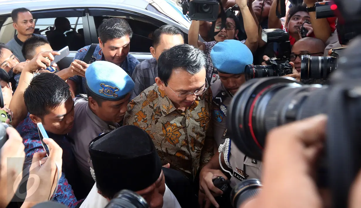 Basuki Tjahaja Purnama (Ahok) mendapat pengawalan ketat setibanya di Bareskrim Mabes Polri, Jakarta, Selasa (22/11). Ahok yang diperiksa sebagai tersangka kasus dugaan penistaan agama ini enggan berkomentar. (Liputan6.com/Johan Tallo)