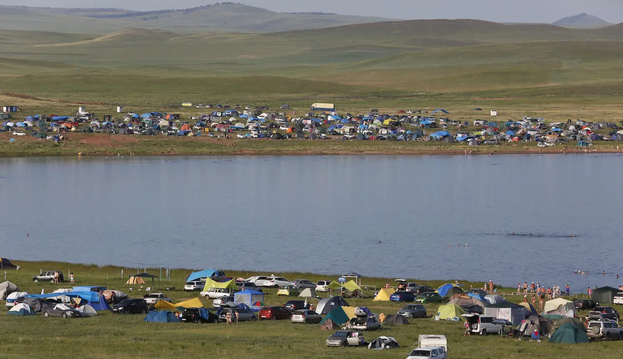 Sejumlah mobil dan tenda wisatawan terlihat memadati tepi Danau Tus, Khakassia, Siberia Krasnoyarsk, Rusia (18/7/2015). Danau Tus terkenal akan lumpurnya yang kaya mineral sehingga diyakini bisa menyembuhkan beberapa penyakit. (REUTERS/Ilya Naymushin)