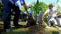 Corporate Secretary Bank BTN Ari Kurniaman (kanan) saat penanaman bibit pohon kelapa hibrida pandan wangi di Pantai Air Manis, Kota Padang, (7/01/2022). Bantuan ini merupakan bagian dari kegiatan Tanggung Jawab Sosial dan Lingkungan (TJSL) perseroan. (Liputan6.com/HO/BTN)